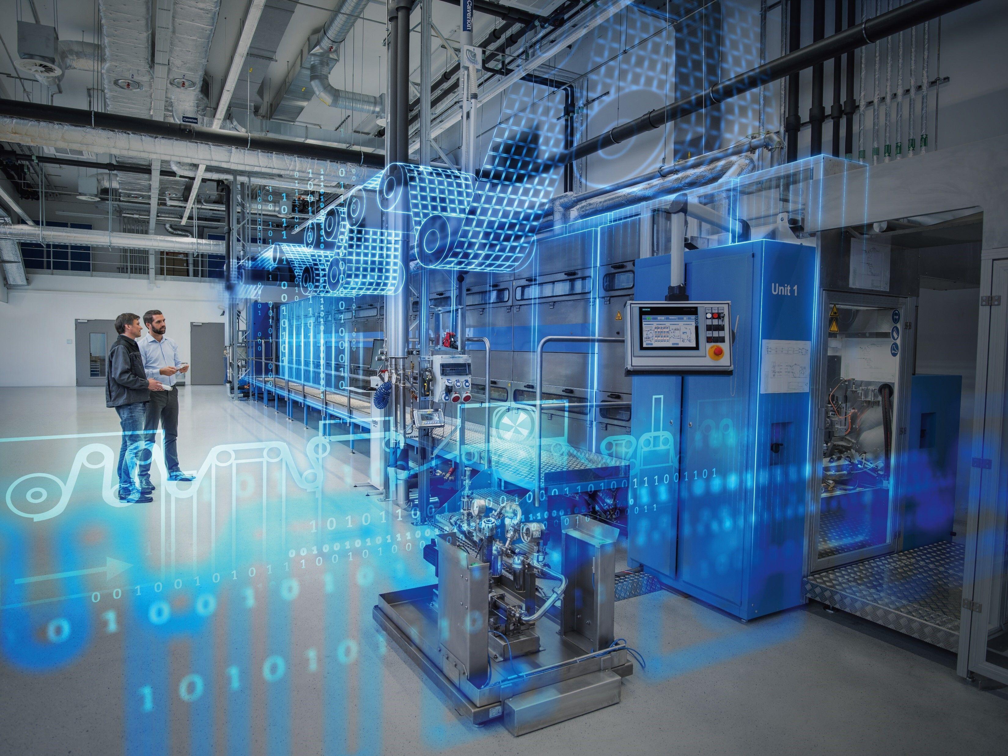 Das Bild zeigt eine moderne industrielle Anlage mit fortschrittlicher Technologie. Zwei Männer stehen in einem großen, hellen Raum, der mit komplexen Maschinen ausgestattet ist. Auf der rechten Seite befindet sich eine blaue Maschine mit der Aufschrift 'Unit 1'. Ein Bildschirm mit technischen Anzeigen ist sichtbar. Über der Szene sind digitale Grafiken und Binärcode-Elemente eingeblendet, die auf den Einsatz von digitaler Technologie und Automatisierung hinweisen. Die Umgebung wirkt sauber und hochmodern, was auf eine Forschungs- oder Produktionsstätte hindeutet.