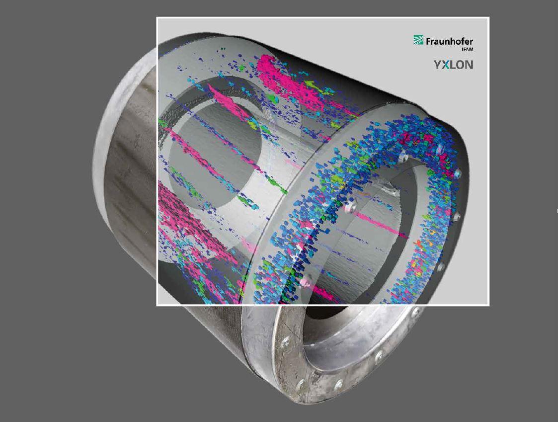 Das Bild zeigt ein zylindrisches Metallteil, das möglicherweise ein Gussteil für die Elektromobilität darstellt. Auf der Oberfläche des Zylinders sind bunte Markierungen in Pink, Blau und Grün zu sehen, die möglicherweise auf eine Analyse oder Untersuchung hinweisen. Im oberen rechten Bereich des Bildes befinden sich die Logos von 'Fraunhofer IFAM' und 'YXLON'. Der Hintergrund ist grau, was den Fokus auf das Metallteil lenkt.